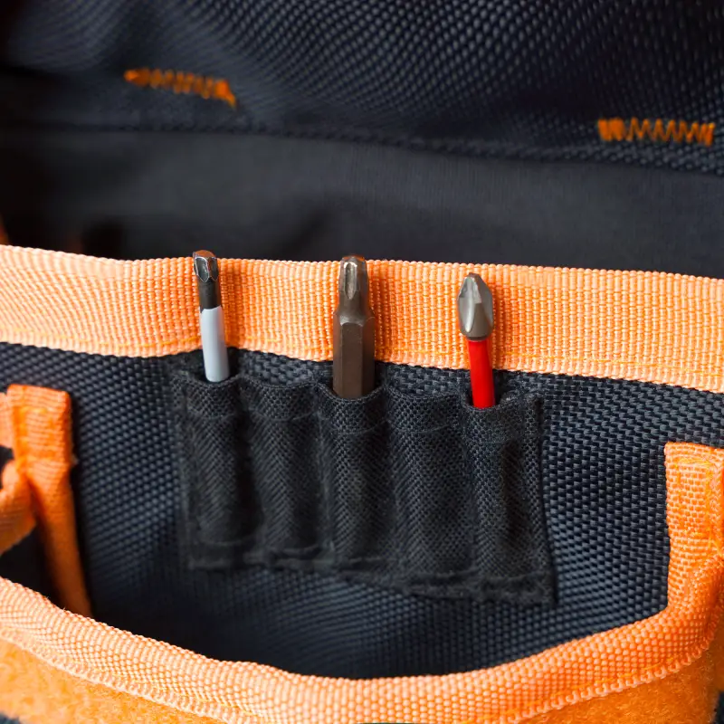 a close-up of 5 bit pockets which have bits in them. each pocket is well designed and stitched, to hold bits strongly and prevent loosing them or to get rid of searching for them among loads of nails in nail pocket. located above nail pocket and on the front side of the durable tool belt